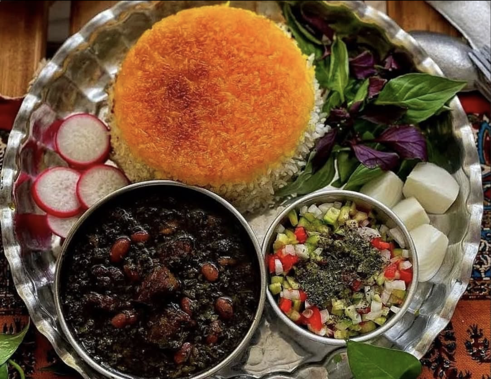 Persische Reisplatte mit Safranreis, Ghormeh Sabzi, frischen Kräutern und Radieschen